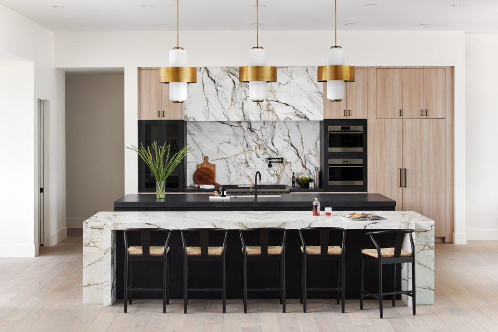 subzero kitchen appliances with custom marble, cabinets and statement lighting