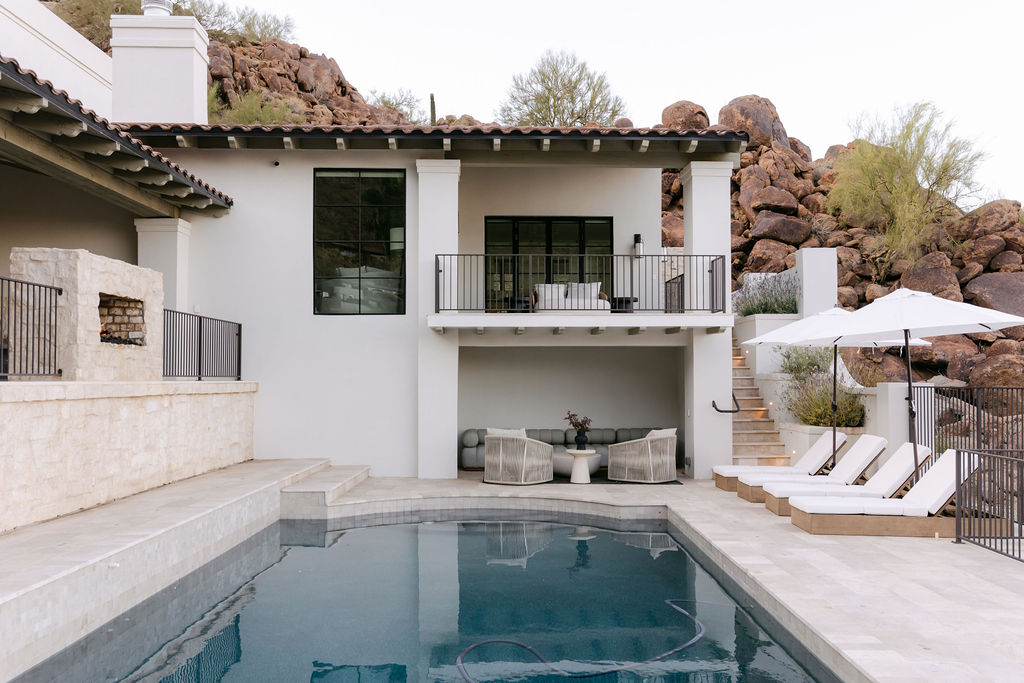 Luxury desert home with a modern pool and covered outdoor lounge, designed for seamless indoor-outdoor entertaining in Paradise Valley, Arizona.