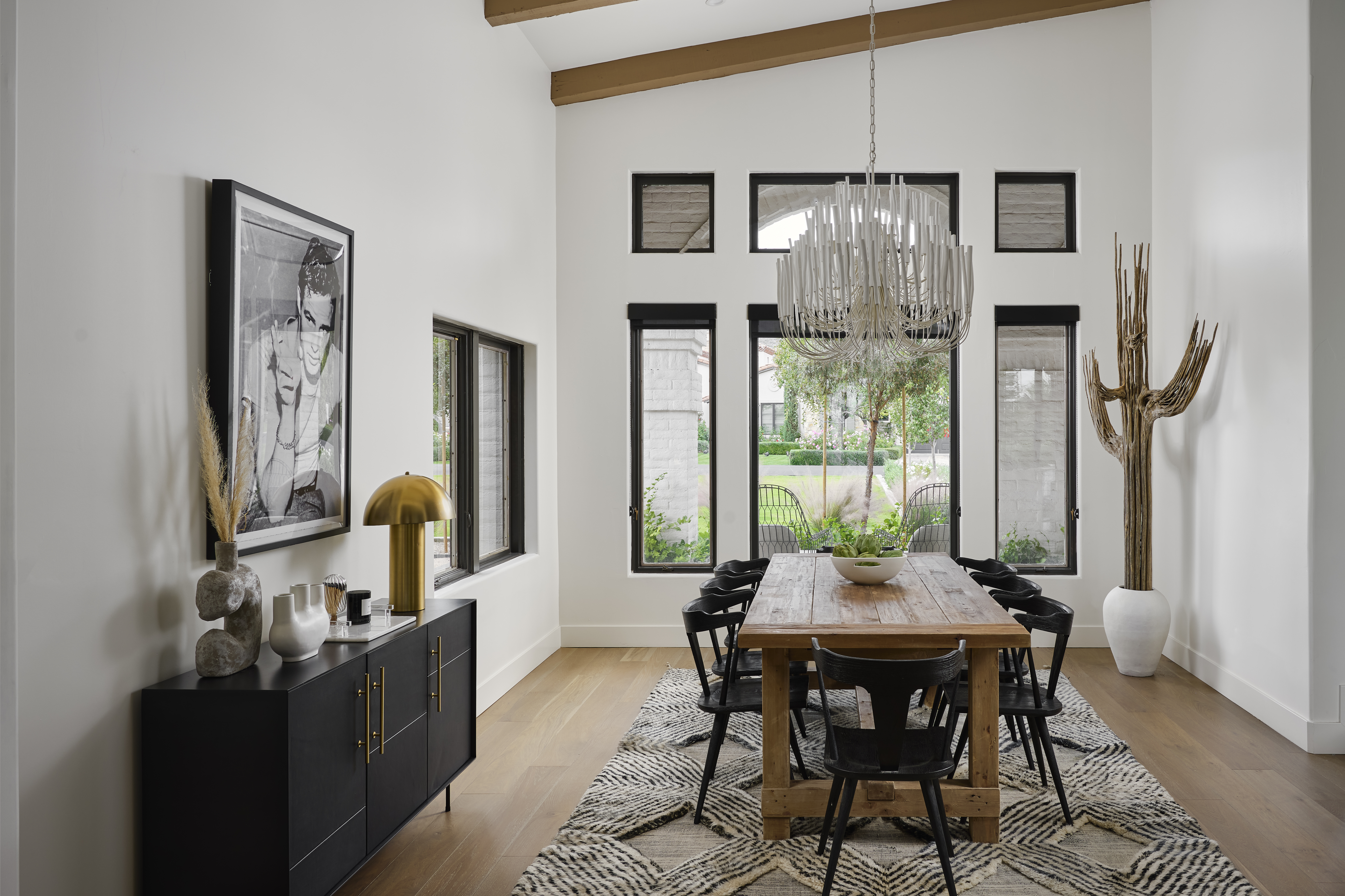 Modern dining room in Paradise Valley home featuring oversized art, sculptural accents, mixed textures, and natural wood tones.