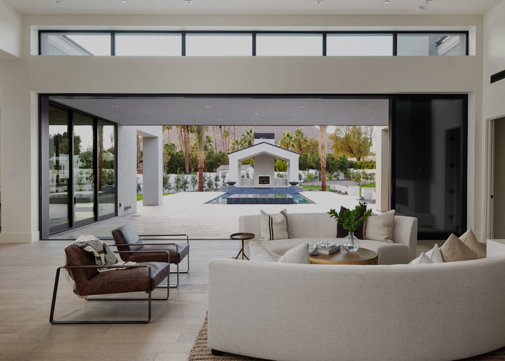 Luxury living room opening to pool and outdoor pavilion in a Scottsdale desert home designed for seamless indoor-outdoor entertaining.