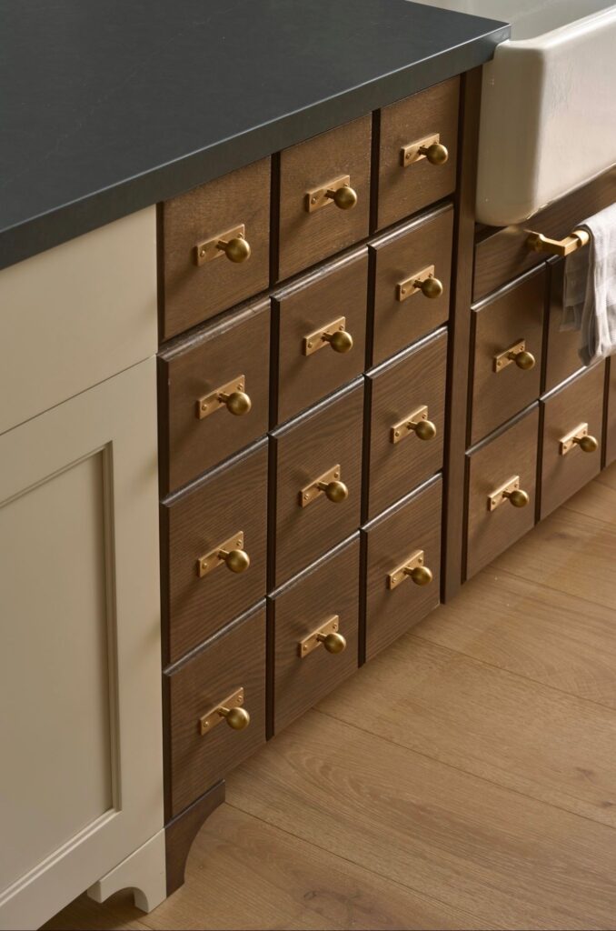 Custom wood cabinetry drawers with brass hardware and integrated sink detail by Smyth House Interior Design.