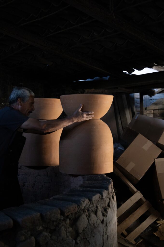 Large sculptural clay pendants resting in a traditional kiln workshop, handcrafted for the Smyth House x Palo Santo Decor lighting collection.