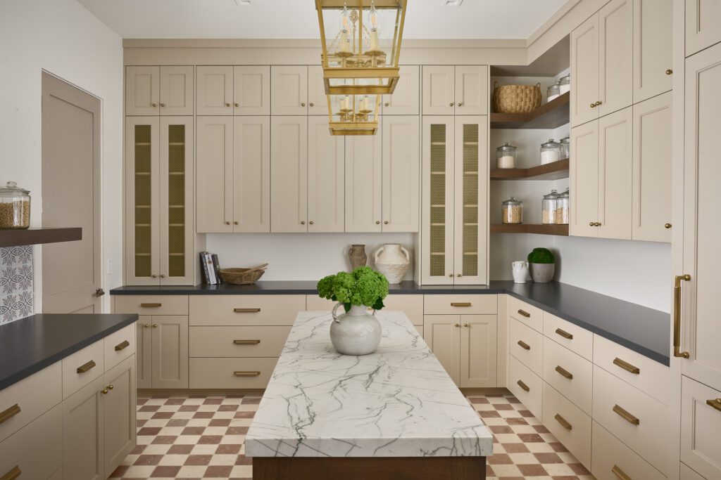 Custom butler’s pantry with cream cabinetry, marble island, brass lighting, and checkered tile floor designed by Smyth House