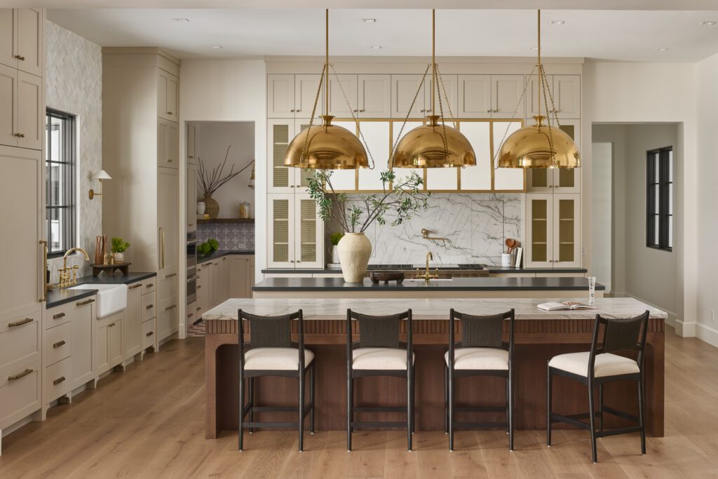 Luxury kitchen with large marble island, brass pendant lighting, and custom cabinetry designed by Smyth House