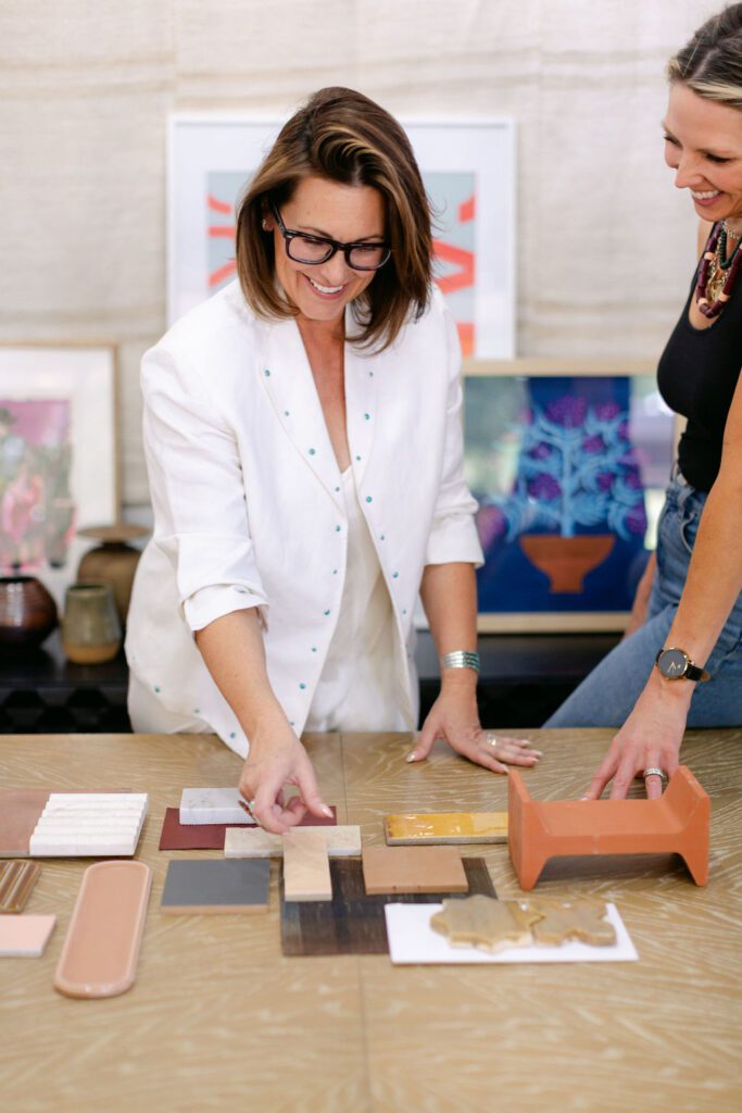 Hiring a Luxury interior designer, Meredith from Smyth House Interior Design reviewing tile and material samples with a client, selecting finishes and textures for a custom luxury home design project.