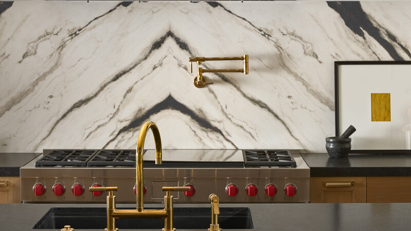 Luxury kitchen designed by Smyth House featuring dramatic marble slab backsplash, brass fixtures, integrated appliances, and layered modern materials in an Arizona home.