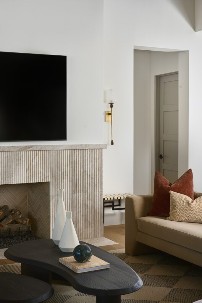 Luxury living room designed by Smyth House featuring a textured stone fireplace, warm neutral furnishings, layered materials, and modern Arizona interior design details.
